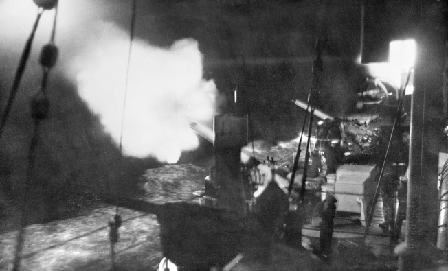 In the dark: The Australian cruiser Canberra conducting a night-firing drill. Canberra fired only a few rounds before she was left dead in the water.