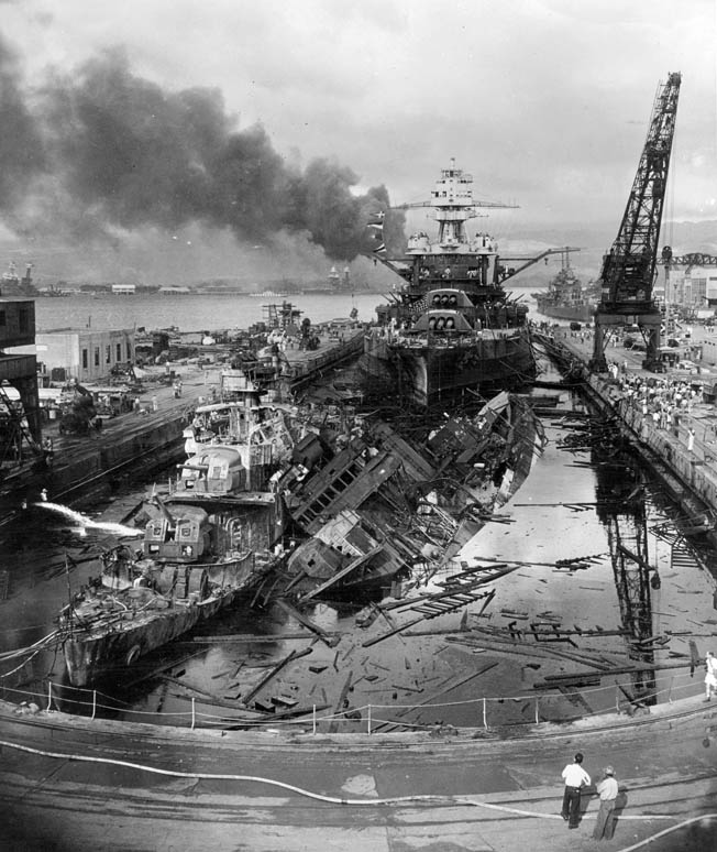 The battleship USS Pennsylvania lies in drydock in Pearl Harbor during the aftermath of the Japanese attack on December 7, 1941. Just forward of the battleship lie the severely damaged destroyers USS Downes (left) and Cassin. Pennsylvania sustained some damage, but her crew managed to fight back, firing machine guns and antiaircraft weapons at the attackers.