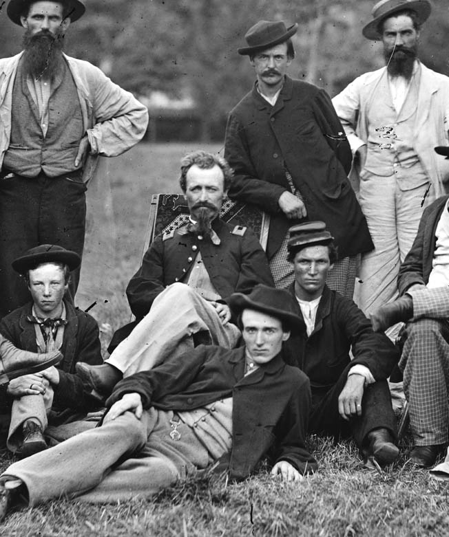Sergeant Milton W. Cline (seated) disguised himself as a Confederate scout and reported on the location of 125 Confederate military camps and other installations during a harrowing mission behind enemy lines in winter 1863.