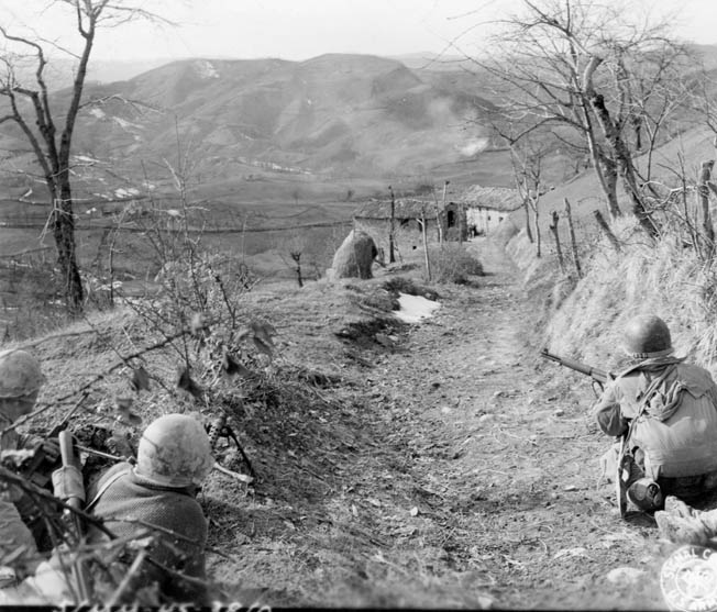 A combat patrol from the 87th Mountain Infantry Regiment prepares to flush out a group of Germans holed up in an Italian farmhouse, March 1945.