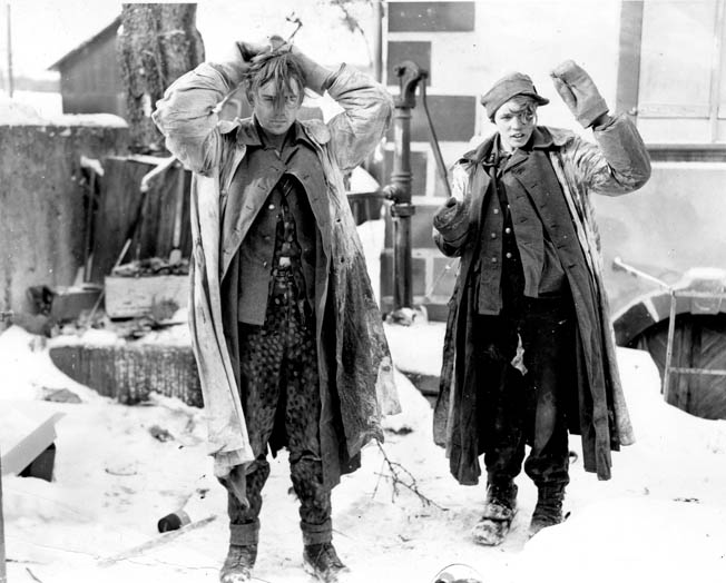 A young SS prisoner, captured by troops of the 103rd Infantry Division, stands with his hands on his head. During the German attack on Mulhouse, France, Ray Miller and his companions took a German soldier prisoner before they were fired upon by enemy troops and the tables were turned.