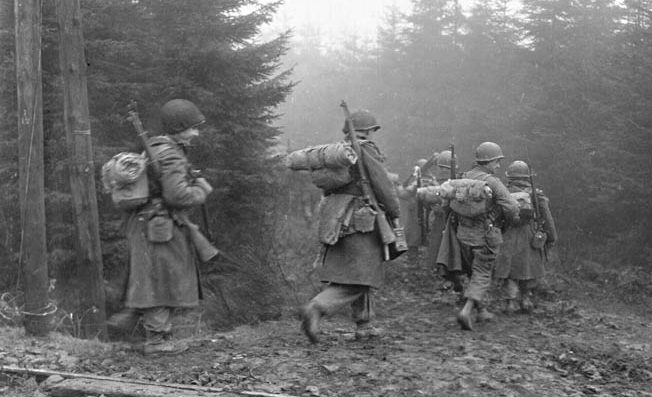 Men of the 325th Glider Regiment, 82nd Airborne, move into the woods in heavy fog during operations in Western Europe. 