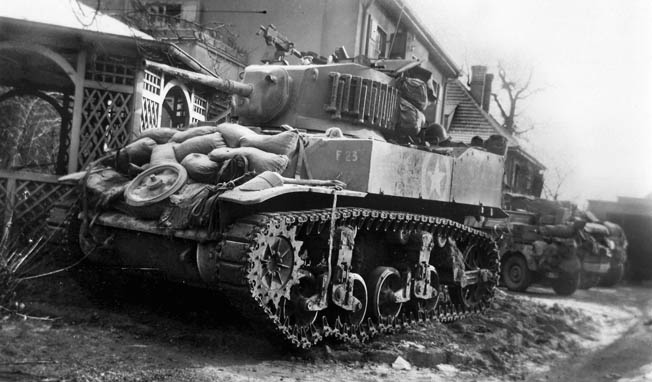 ABOVE: The Stuart light tank was a superb reconnaissance vehicle but its 37mm main weapon was useless against German armor. The 106th Cavalry Squadron fielded the Stuart until the spring of 1945, when medium tanks with 75mm guns became available. This photo was taken in Ludweiler, Germany. BELOW: On January 2, 1945, the day after the German Army launched Operation Nordwind, engineers of the 106th Cavalry Squadron prepare a roadblock to slow the enemy advance a half mile from the town of Ludweiler, Germany.