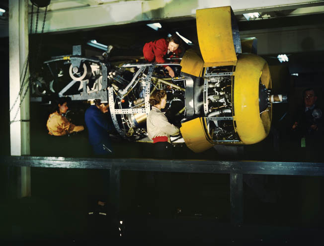 Men and women install an engine in a B-24 at Willow Run. The plant turned out nearly 9,000 planes during the war.