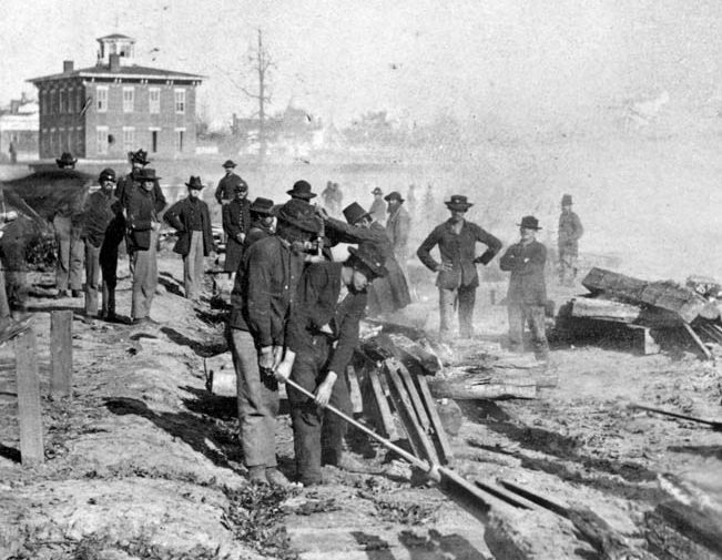 The day before leaving Atlanta, these Union troops left a going away present for hard-pressed Southerners—another bit of twisted railroad tracks known as “Sherman bowties.”