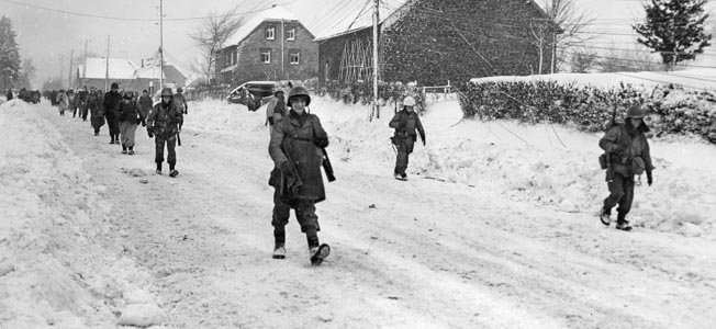 Soldiers of the Big Red One enter snowy Butgenbach, Belgium, on Christmas Eve—the day Puhalovich rejoined his unit after being wounded in the Hürtgen Forest the previous month. 