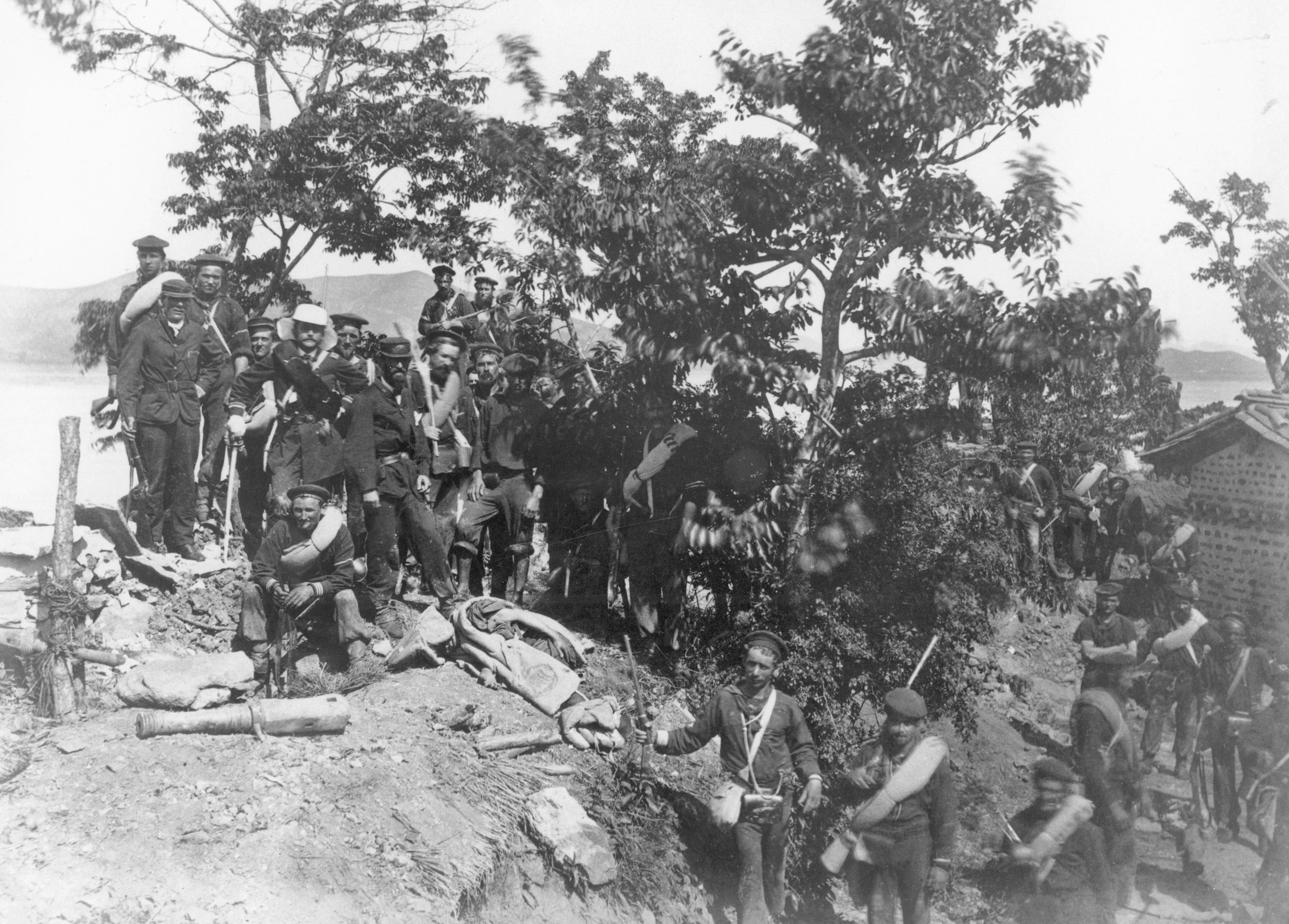 A photograph taken inside the Choji Fort. Lieutenant McKee can be seen standing fifth from left in the white cap, sword in hand. Fiercer fighting was yet to come. 