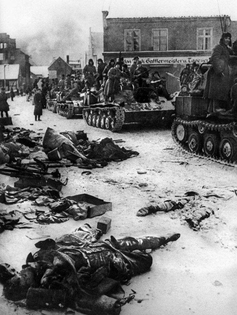 During the advance on Berlin, Soviet soldiers ride atop tanks as they grind their way through a city in East Prussia. The Soviets were merciless and committed many atrocities against the civilian population in retribution for German brutality earlier in the war.