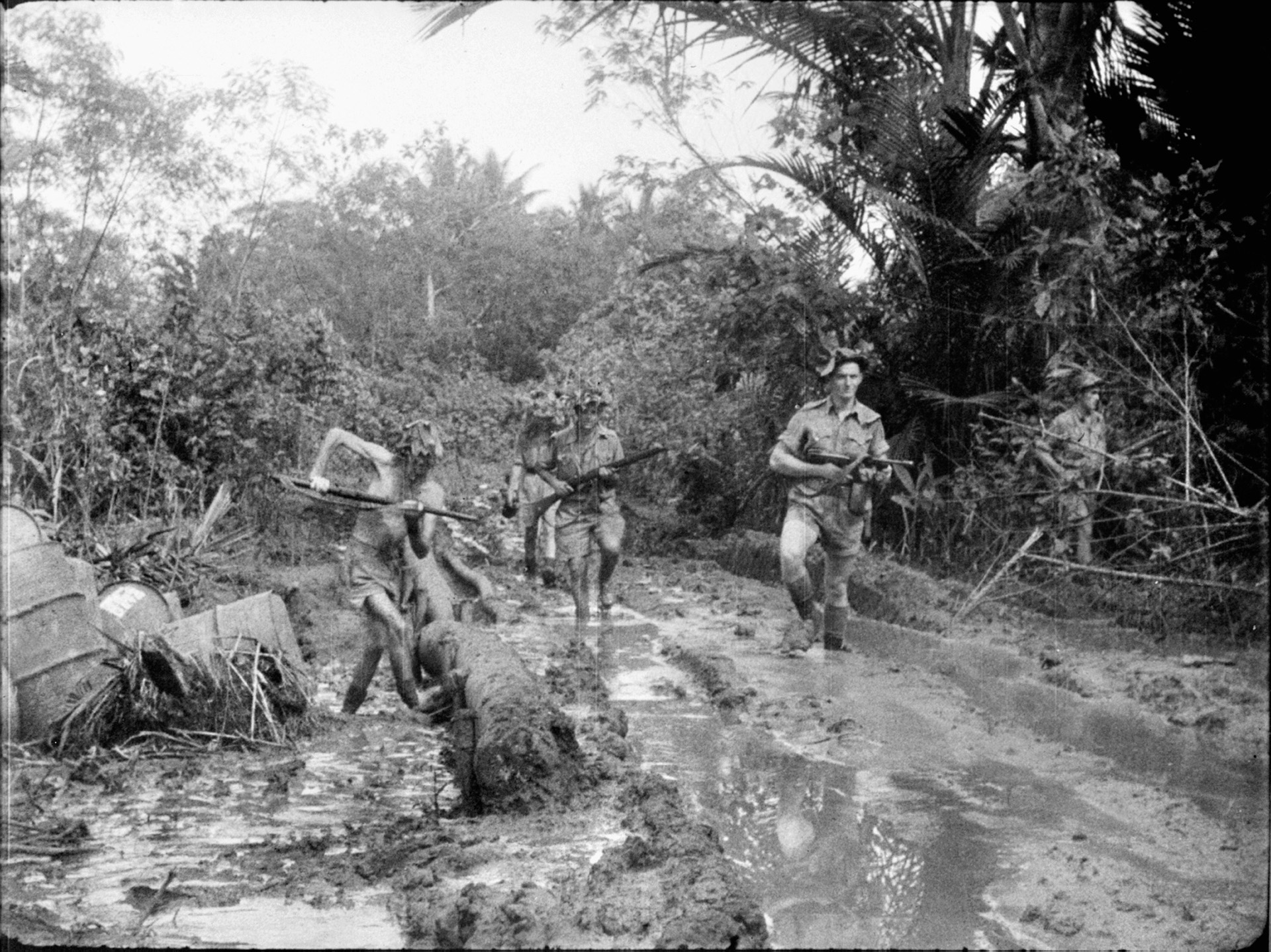 Australian troops, just coming off an unsuccessful engagement with Japanese infantry, slog their way through the mud in early October 1942.