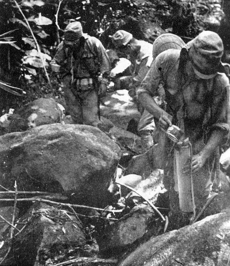 Potable water was a precious commodity in New Guinea. Here, Japanese soldiers pause to refill their canteens.
