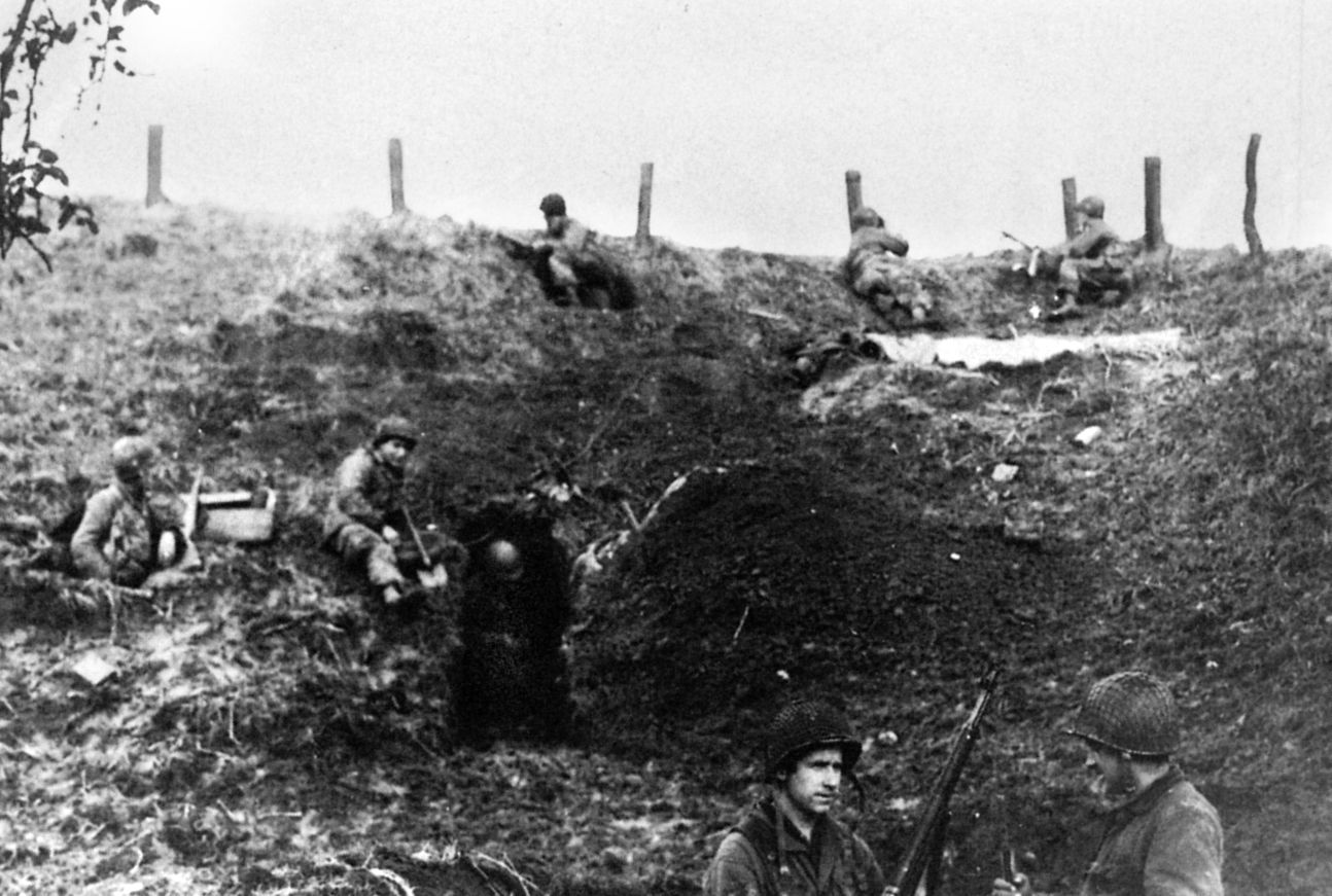 Men of E Company, 506th PIR, take a watchful break at the “Island” dike after taking it from the Germans, November 1944. 