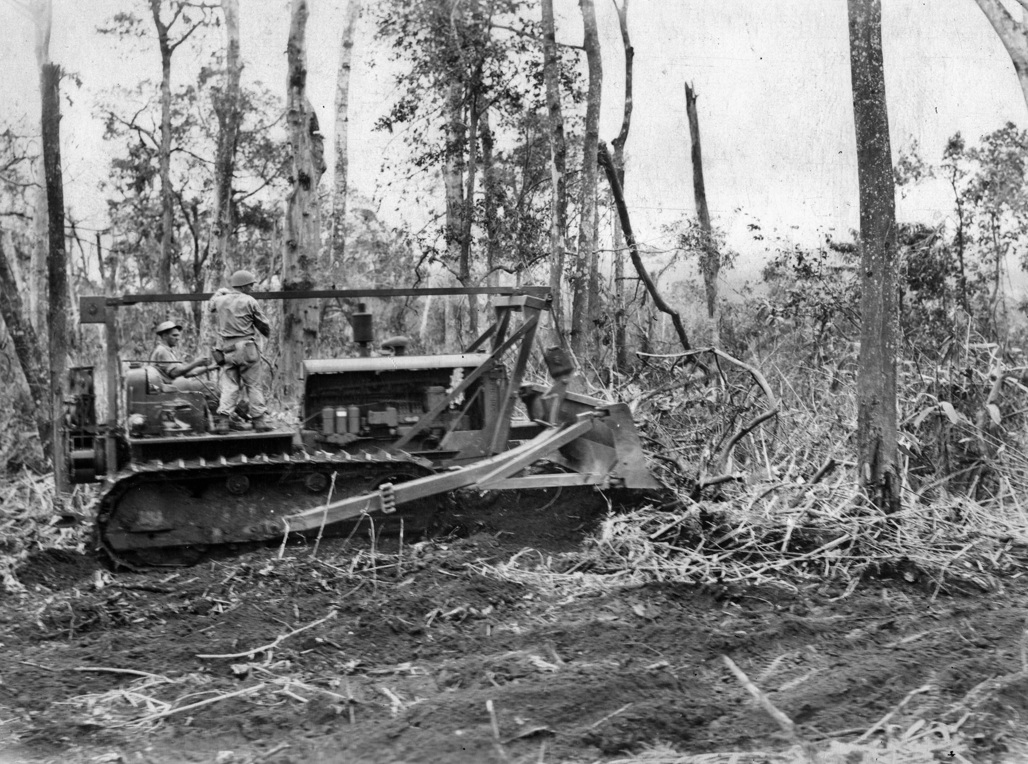 Heavy equipment such as this bulldozer was used to clear areas for supply depots and aid stations and to cut primitive roads through the jungle. At times, bulldozers were used in combat to silence particularly stubborn Japanese strongpoints. 