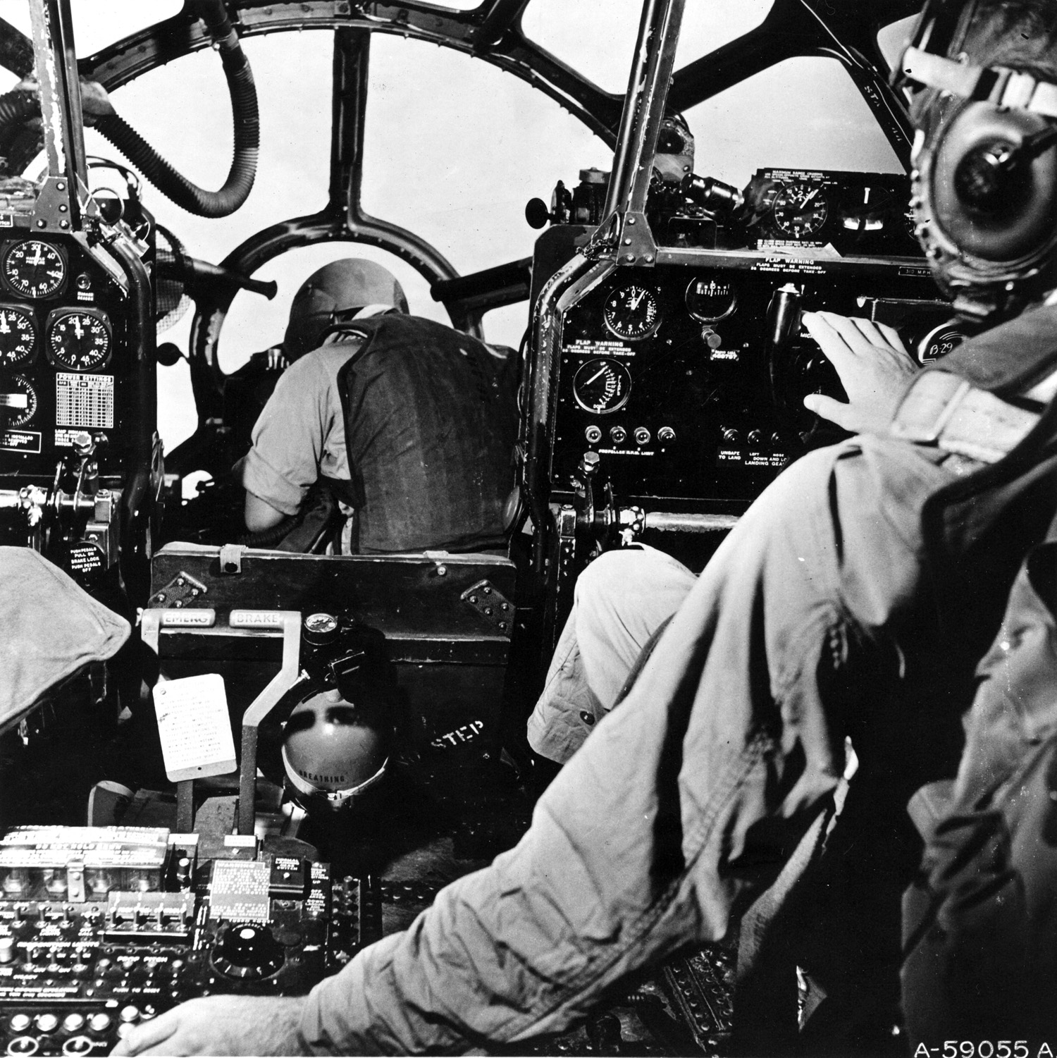 A B-29 Superfortress bombardier, forward of the pilot and co-pilot, is shown at work in his “office.”