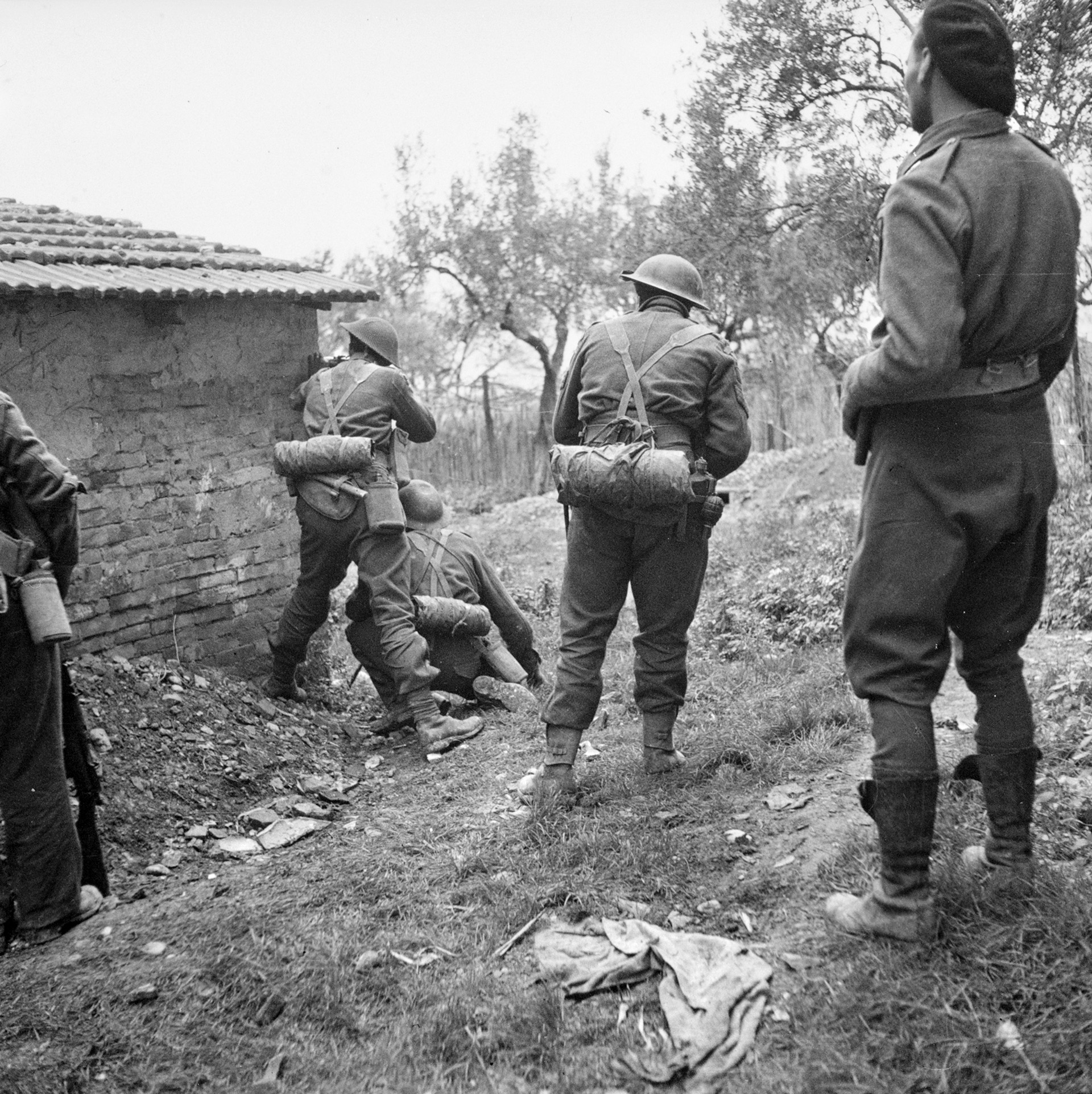Soldiers of the Canadian Loyal Edmonton Regiment peer around a building to fire on the enemy. The Canadians had to fight house to house to secure the strategic Italian city. 