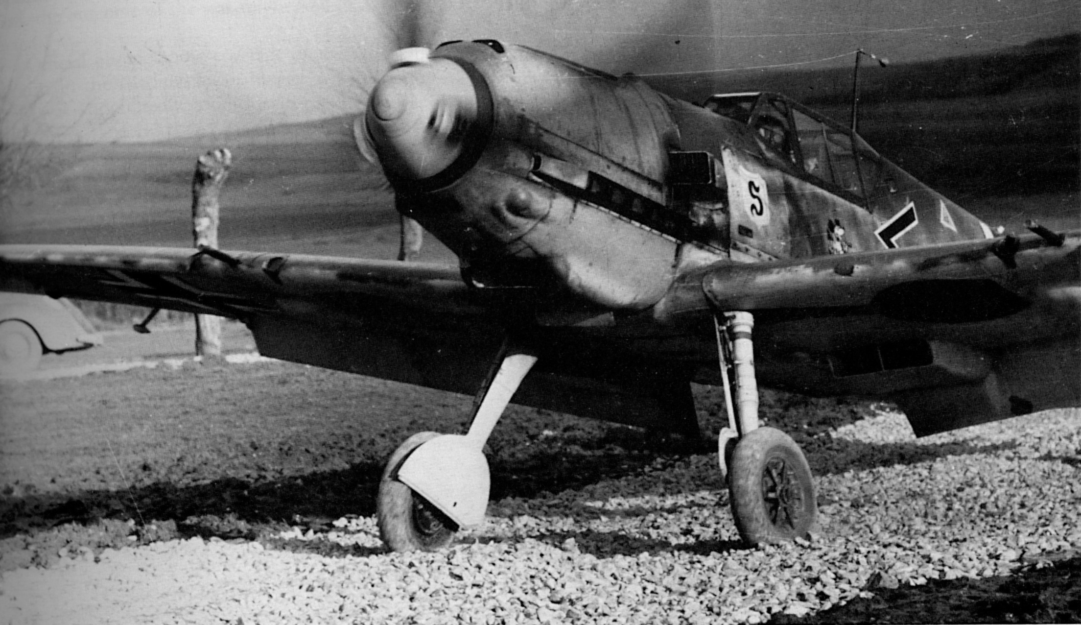 Galland taxis his Bf 109E at Abbeville, France. The gravel was laid to counteract mud but must have been a challenge to the fliers. 