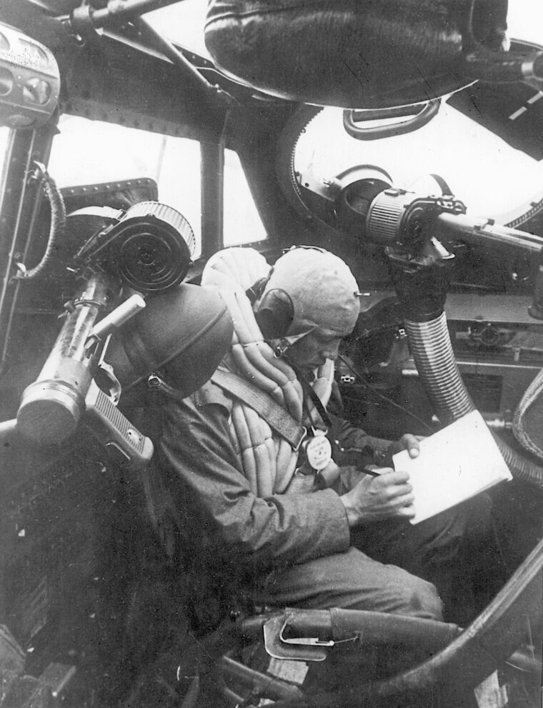 A German radioman-gunner transcribes a message in his Junker Ju-88 medium bomber. He wears a flotation vest in case his plane goes down in the Channel.
