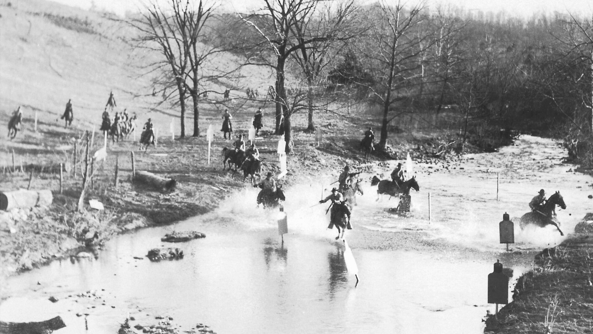 Cadets of the Virginia Military Institute urge their horses across a wintry stream.