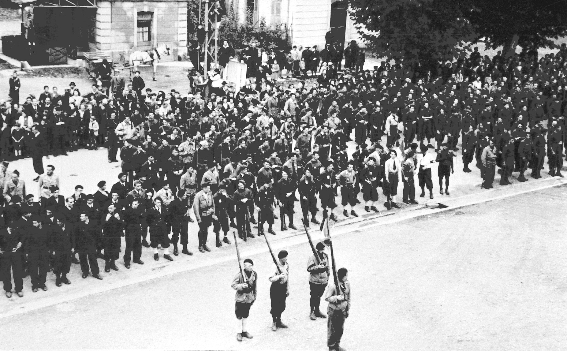 Victory won, an honor guard of Resistance members stands at attention while crowds line the streets of Albertville.