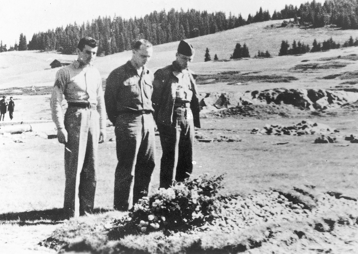 Marines (left to right) John P. Bodnar, Frederick J. Brunner, and Jack R. Risler stand at the grave of comrade Charles Perry, August 2, 1944.