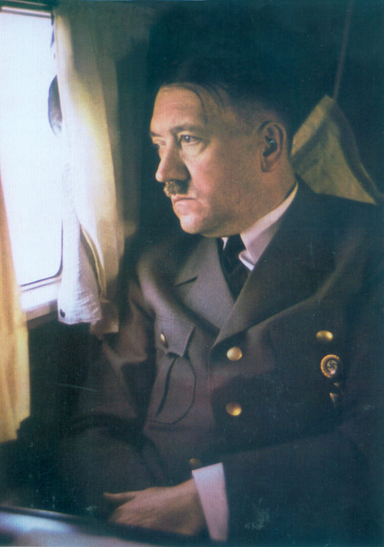 Hitler stares out the window of his personal aircraft in a wartime photo. He is wearing the gold Nazi Party Badge he later gave to Magda Goebbels before his suicide in 1945.