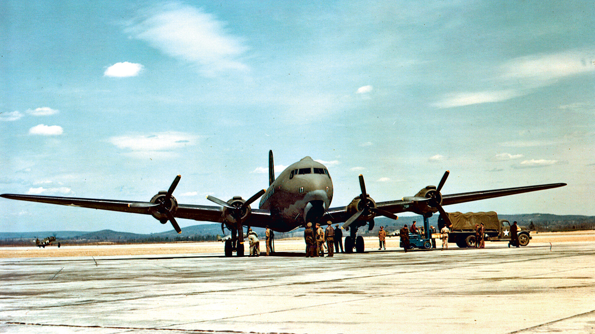 A C-54 transport, the military designation of the Douglas DC-4, is loaded and prepared for takeoff on one of the many crucial supply missions.