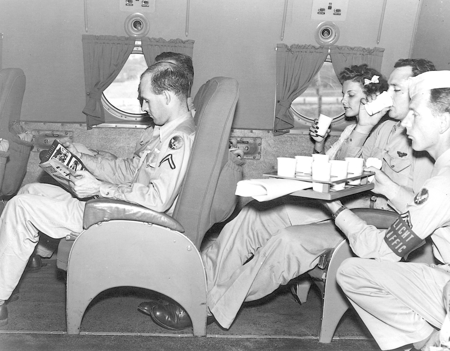 A steward serves lunch to passengers traveling in relative comfort aboard a C-54E in April 1945.