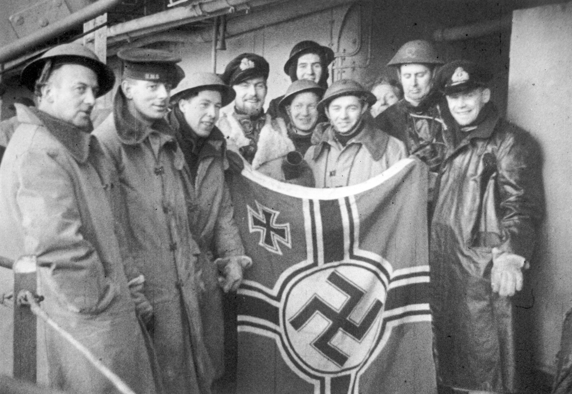 British Commandos display a captured Nazi battle ensign.