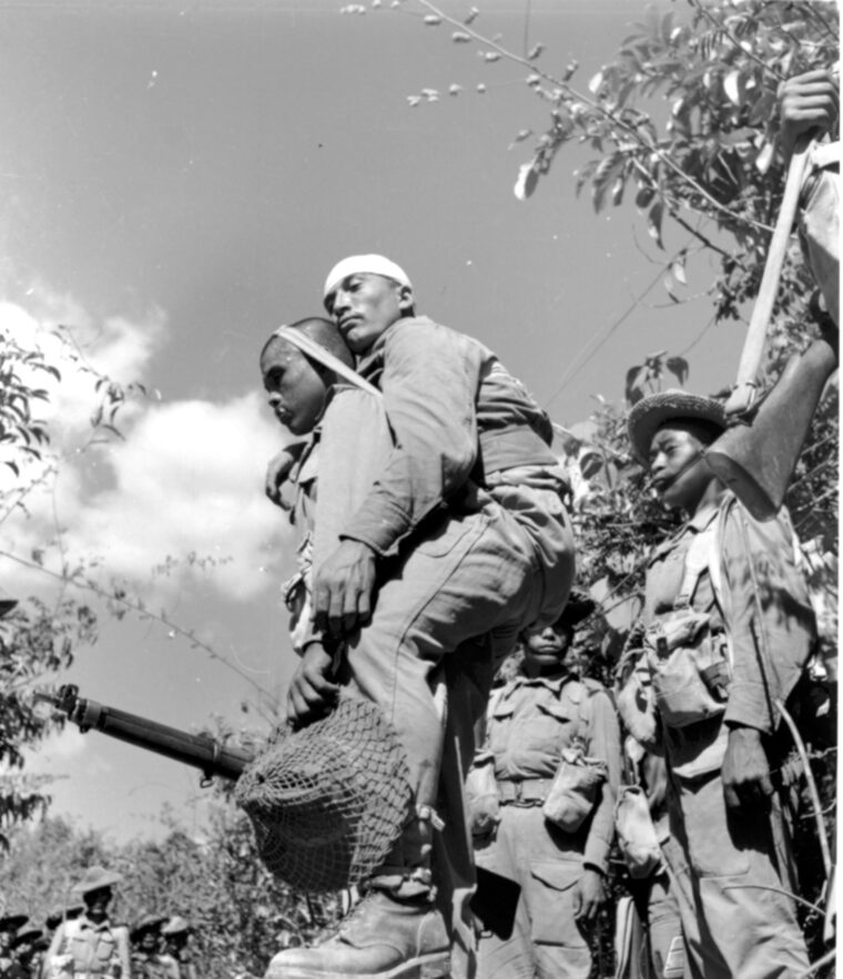 Caring for a comrade: A Gurkha carries a fellow soldier out of harm’s way. The British XV Corps suffered 3,505 casualties at Admin Box, compared to approximately 5,000 casualties for the Japanese.