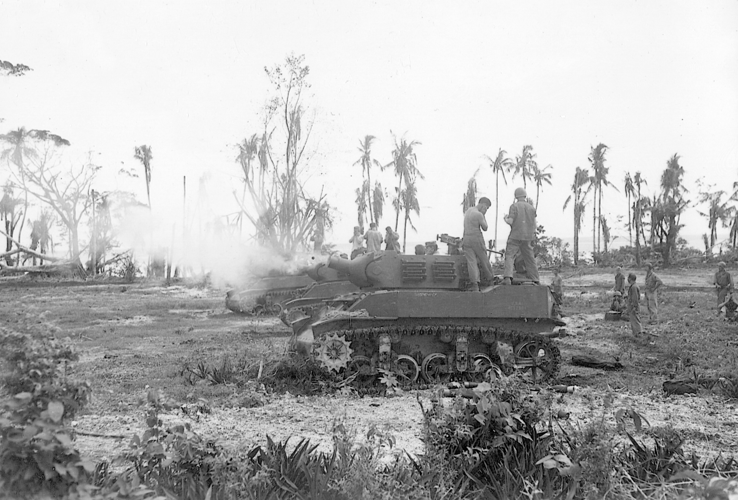 Firing a battery of self-propelled artillery, members of the 24th Infantry Division soften up enemy entrenchments on New Guinea.