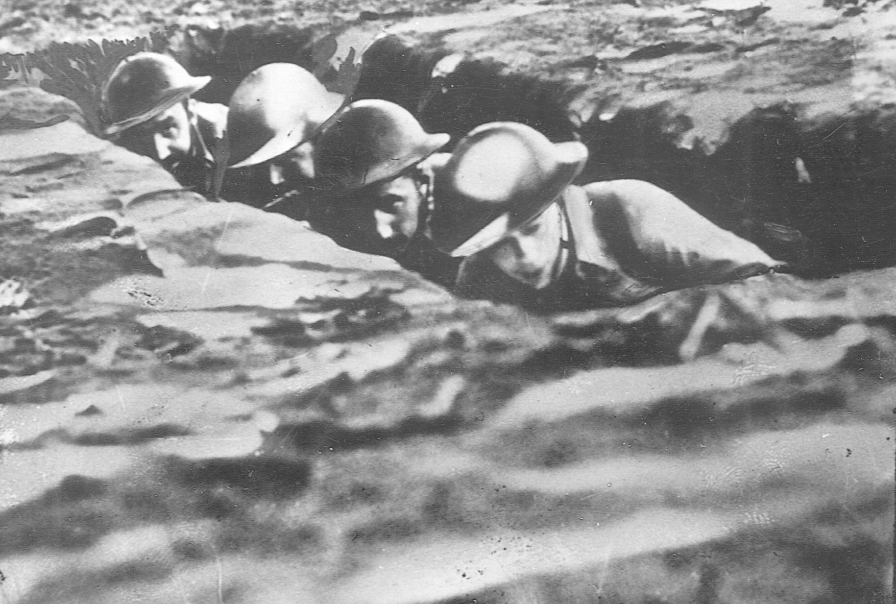 American soldiers hunker down in a trench on embattled Bataan as they come under intense Japanese shellfire.