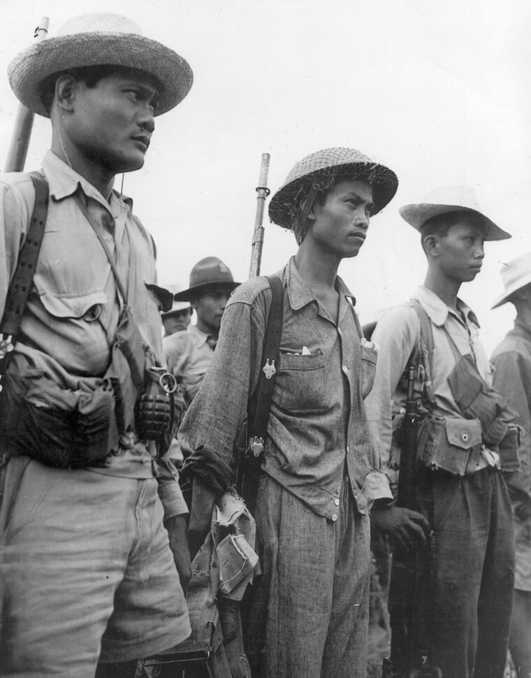 Veterans of jungle combat, Filipino guerrillas who participated in the liberation of the prison camp at Cabanatuan stand in ranks prior to receiving new orders.