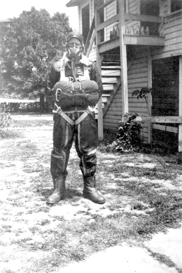 His oxygen mask and parachute in place, Hugh Hunter Hardwicke, Jr., poses in full flying gear during a period of intense training.