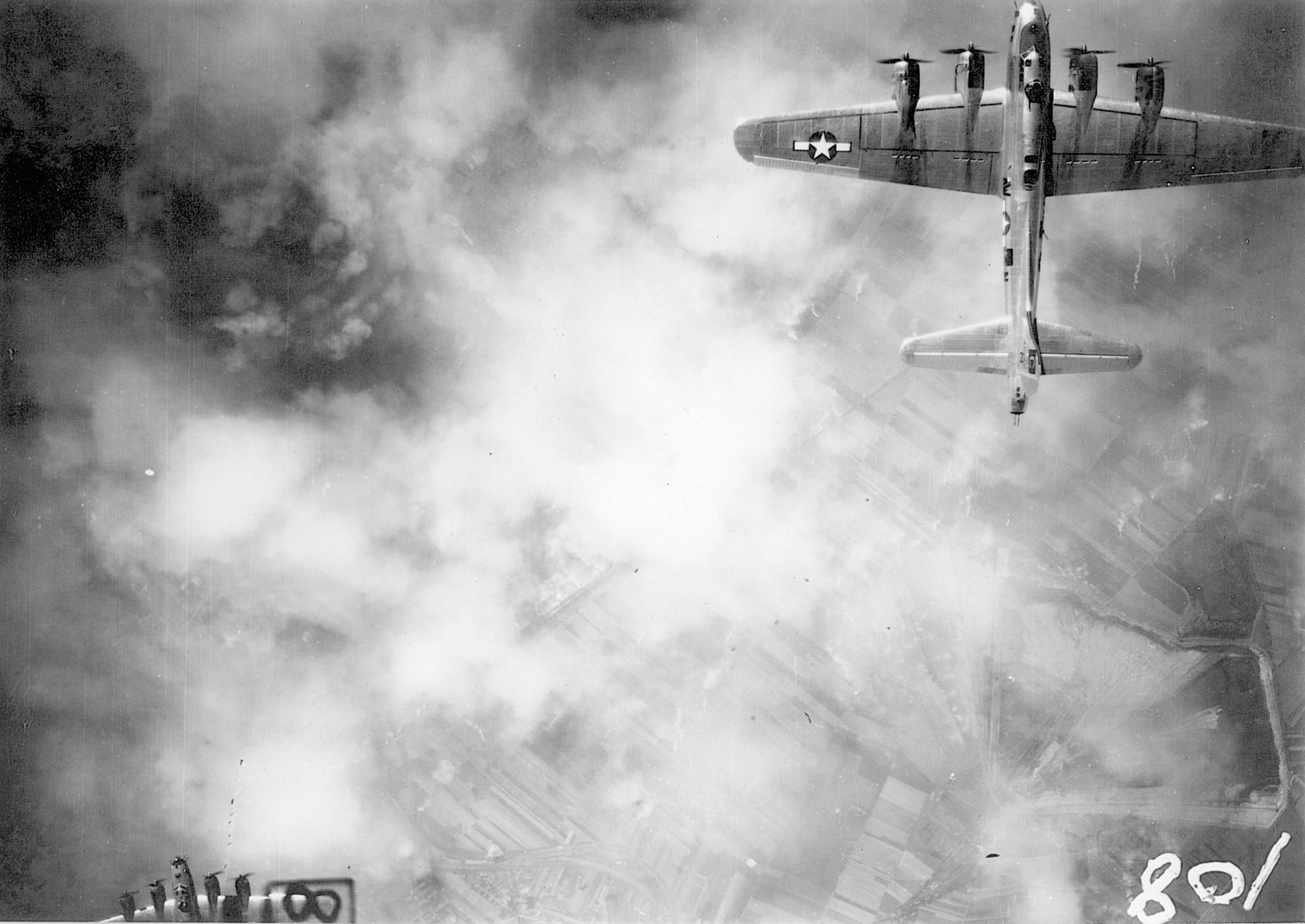 The Leuna Synthetic Oil Works at Merseburg, Germany, were subjected to intense Allied bombing on more than one occasion. A B-17 of the 96th Bombardment Group flies above the smoke and flame of one such attack.