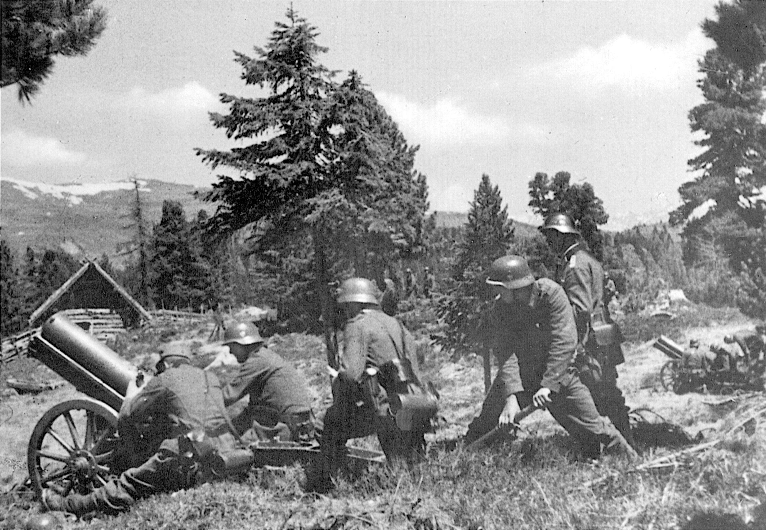 During warmer days, German mountain troops prepare to engage the enemy with a portable howitzer. Usually, the lightly armed mountain troops depended on artillery of this type, mostly 75mm, for firepower in difficult terrain.