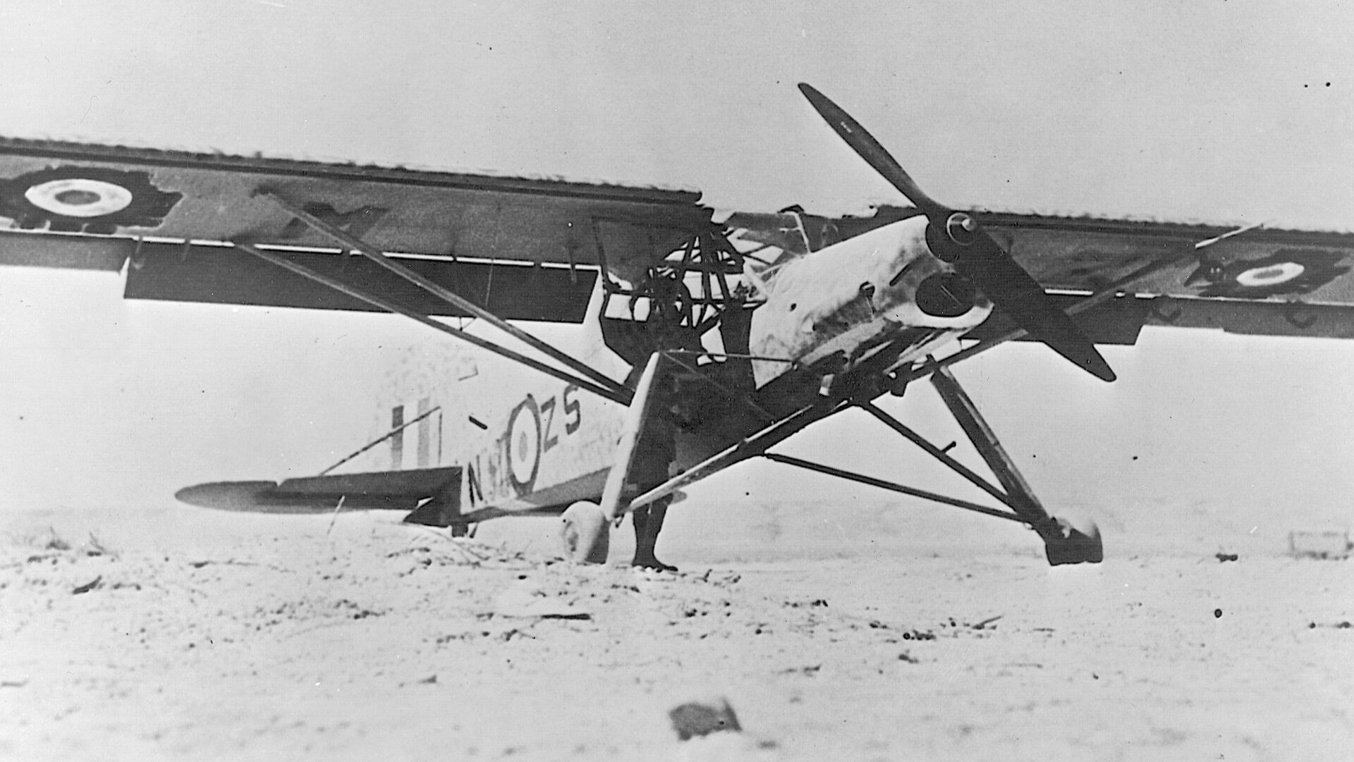 A captured Fieseler Storch bearing British markings sits in the desert.