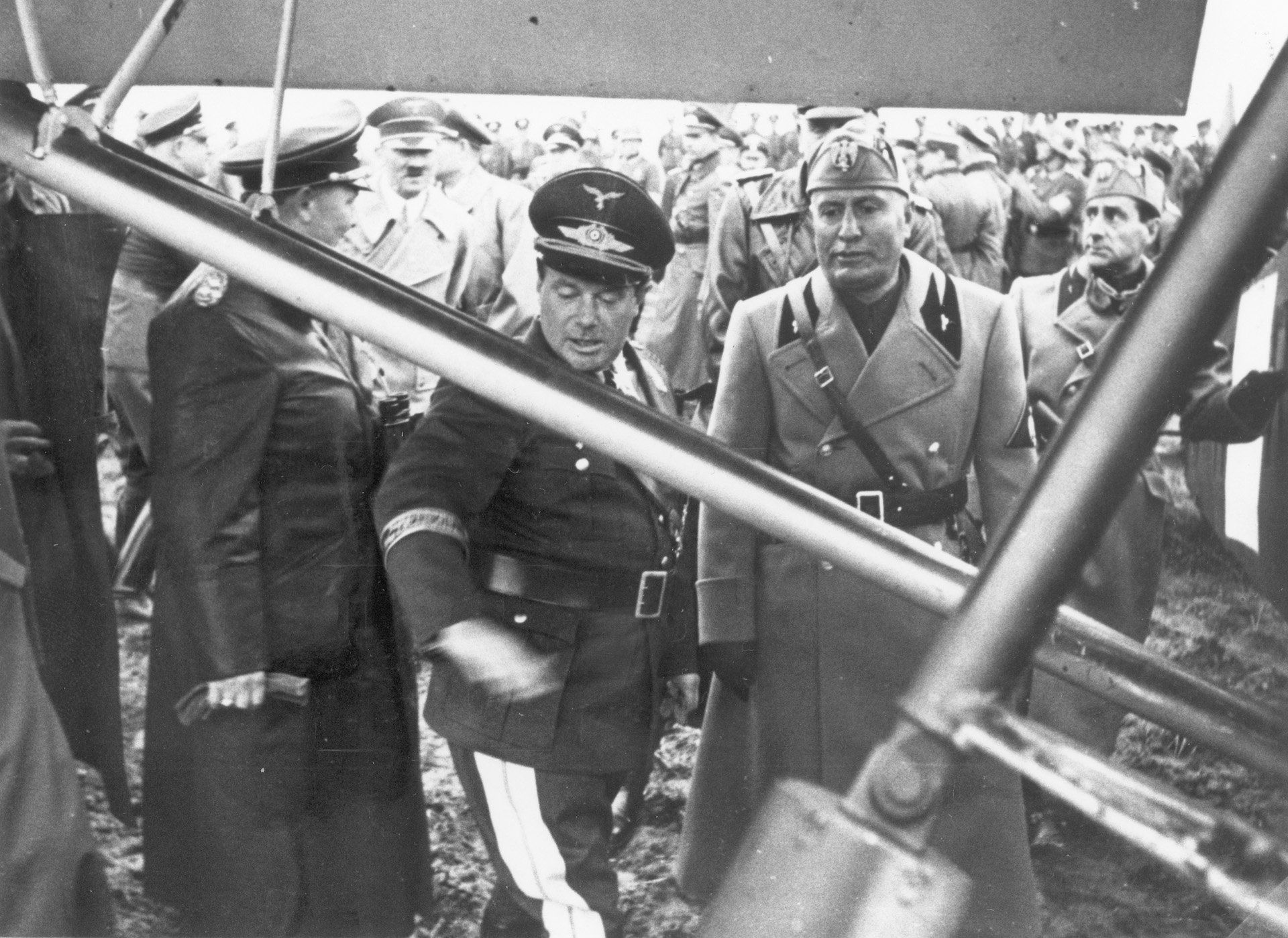 Luftwaffe General Ernst Udet describes features of the Storch to Mussolini while a crowd, which includes Hitler (background), looks on, September 1939.
