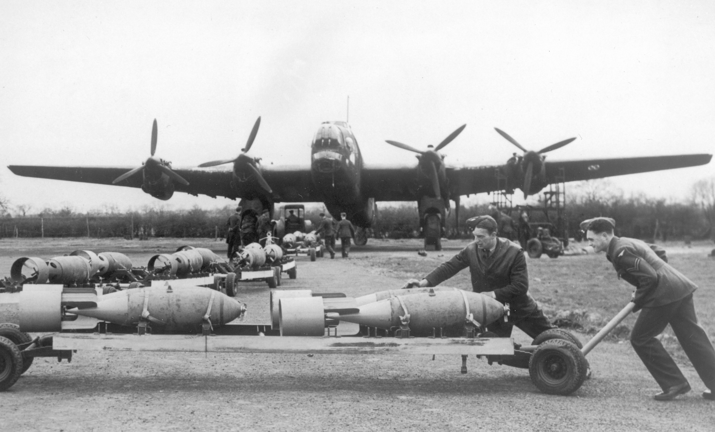 Bomb handlers load ordnance aboard a four-engine RAF bomber in preparation for one of many nocturnal missions against the ancient German city of Cologne.