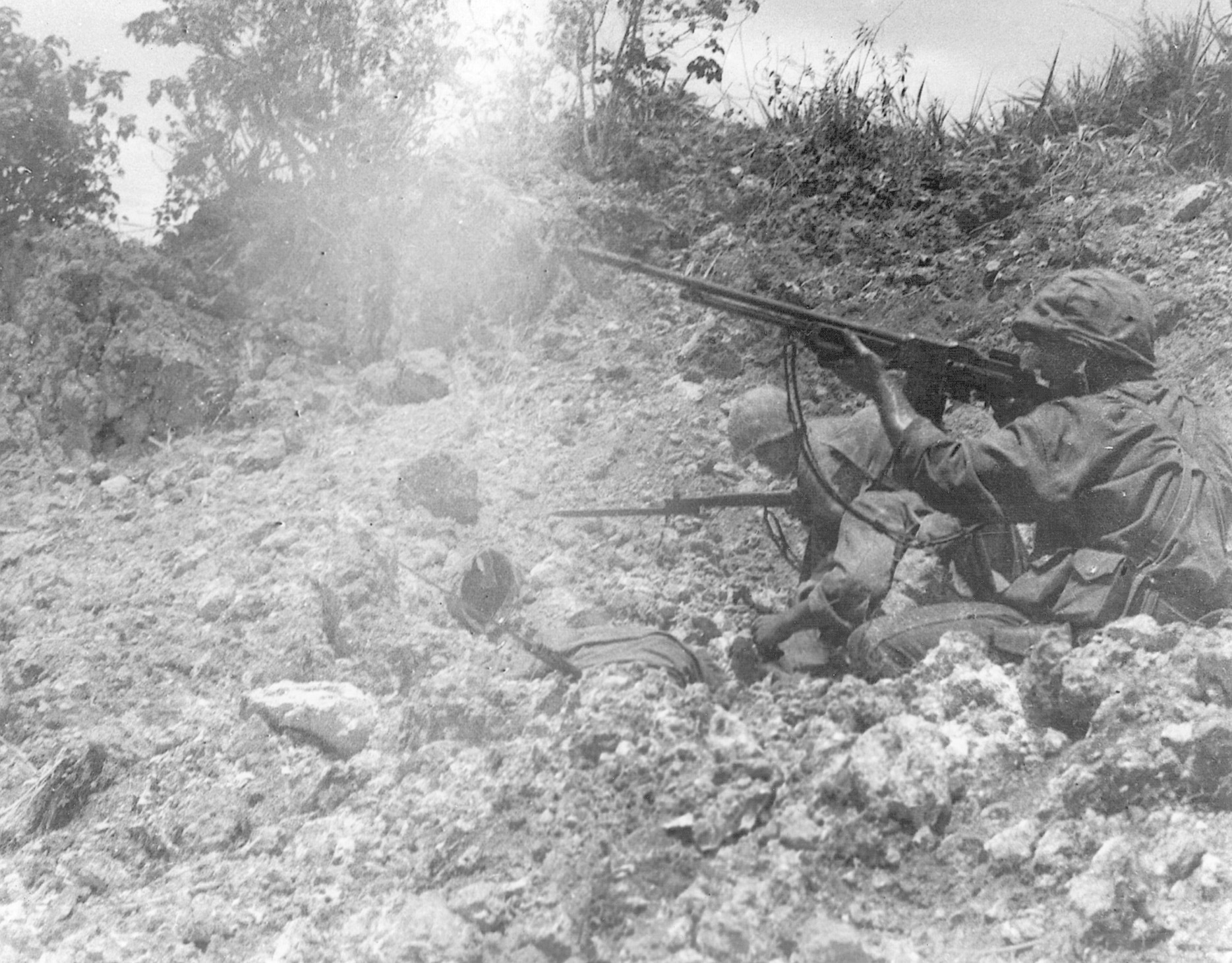From an exposed position roughly 400 yards ahead of the front line, a Marine rises to fire his Browning Automatic Rifle (BAR).