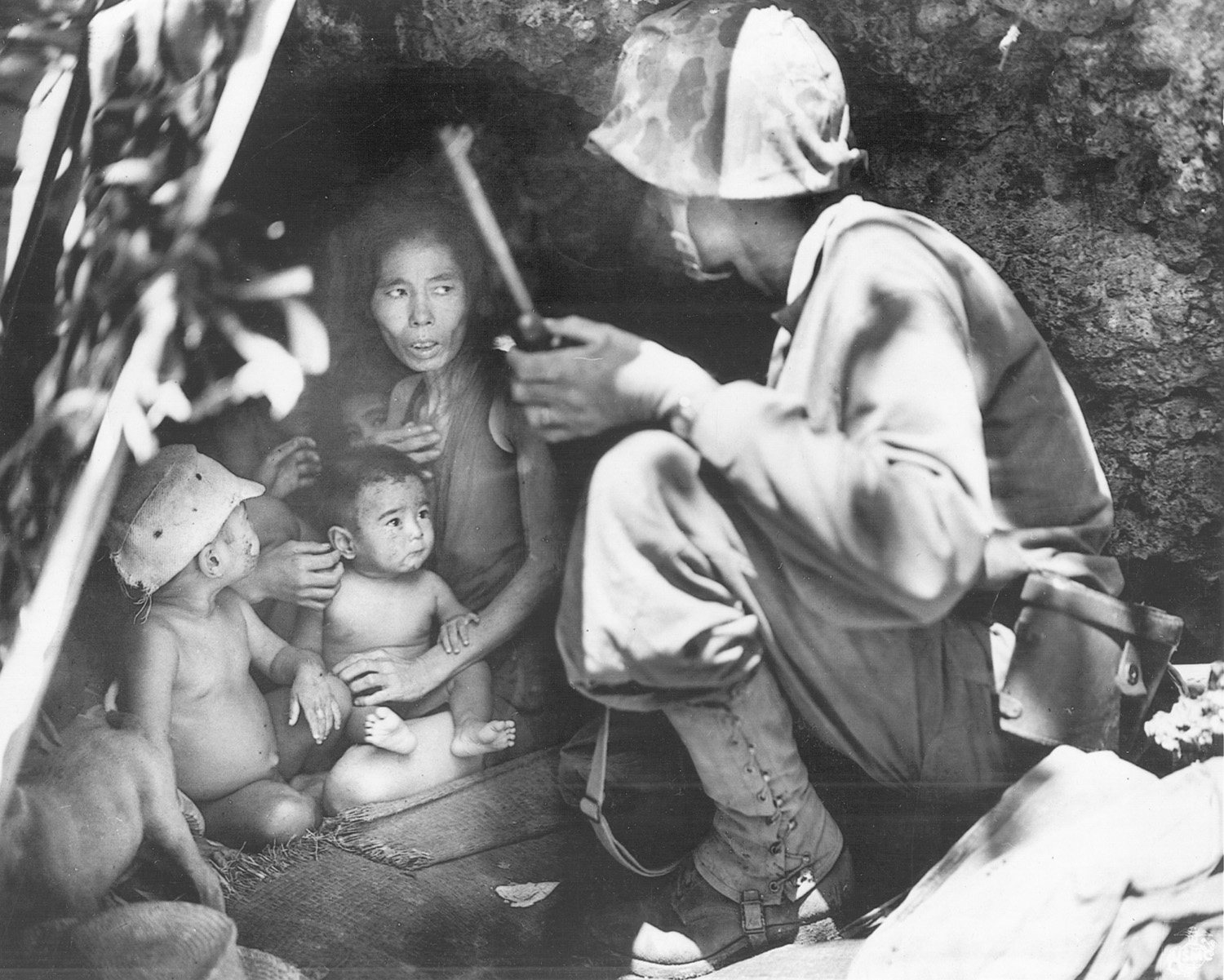 A Japanese family, hidden in a Saipan cave, is discovered by a member of a Marine patrol.