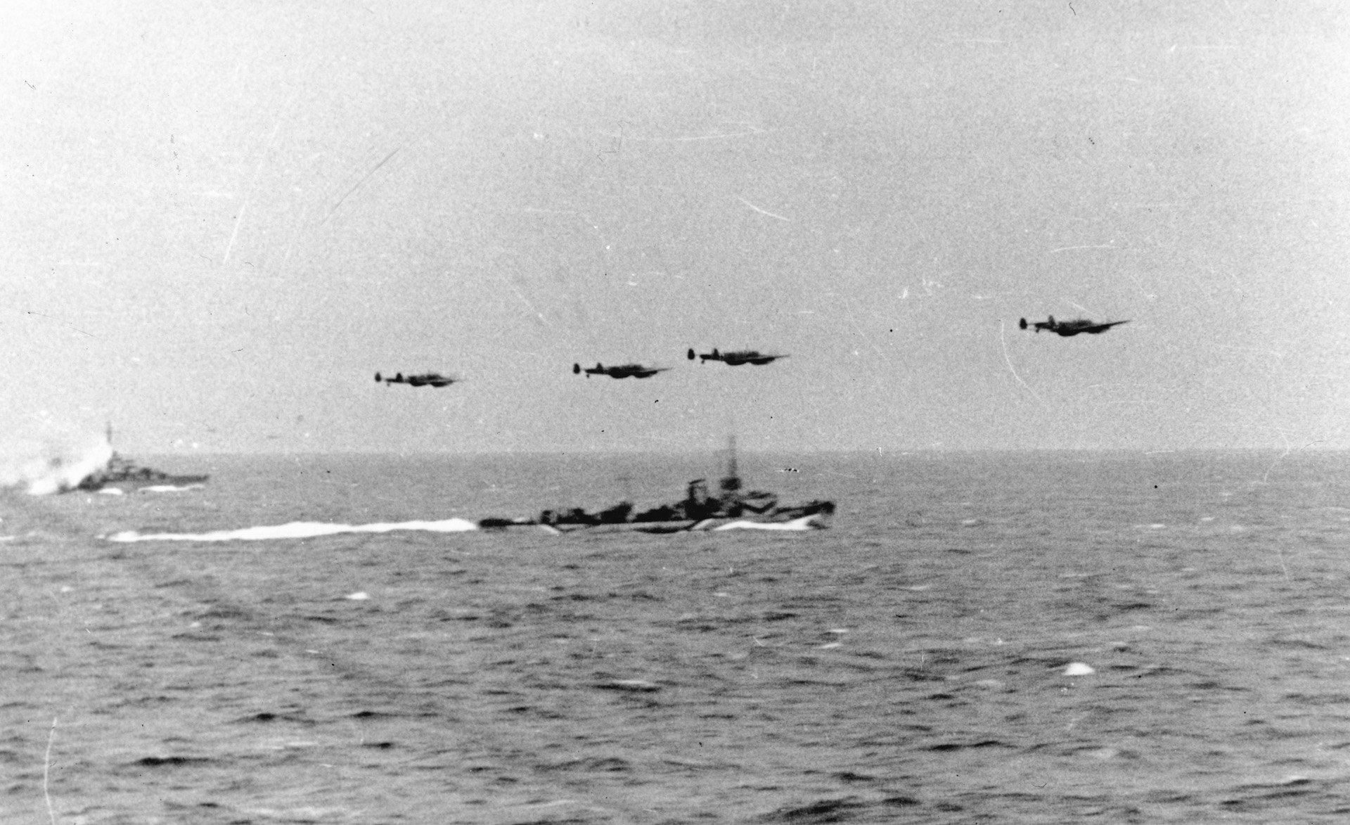 In a photo taken from the cruiser Prinz Eugen, German aircraft and escort vessels churn ahead during the Channel Dash of February 1942.