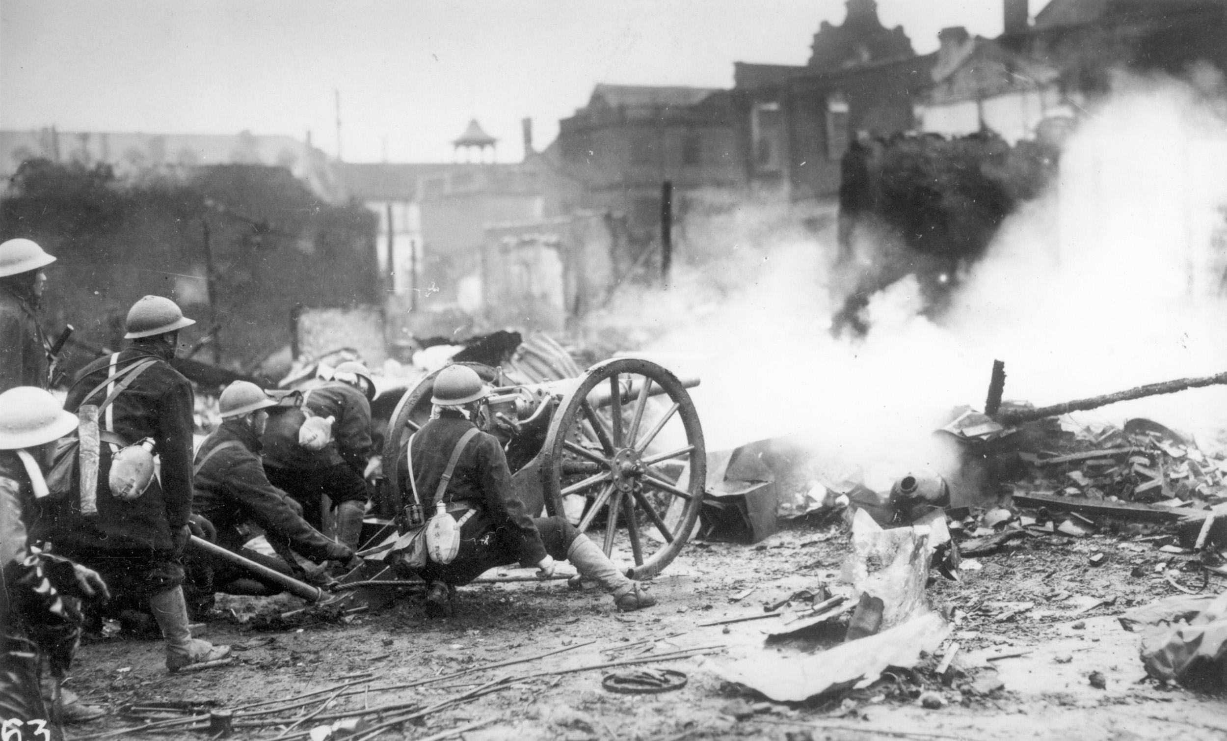 In a rubble-strewn Shanghai street, Chinese soldiers service a small, obsolescent artillery piece during the fighting of 1932.