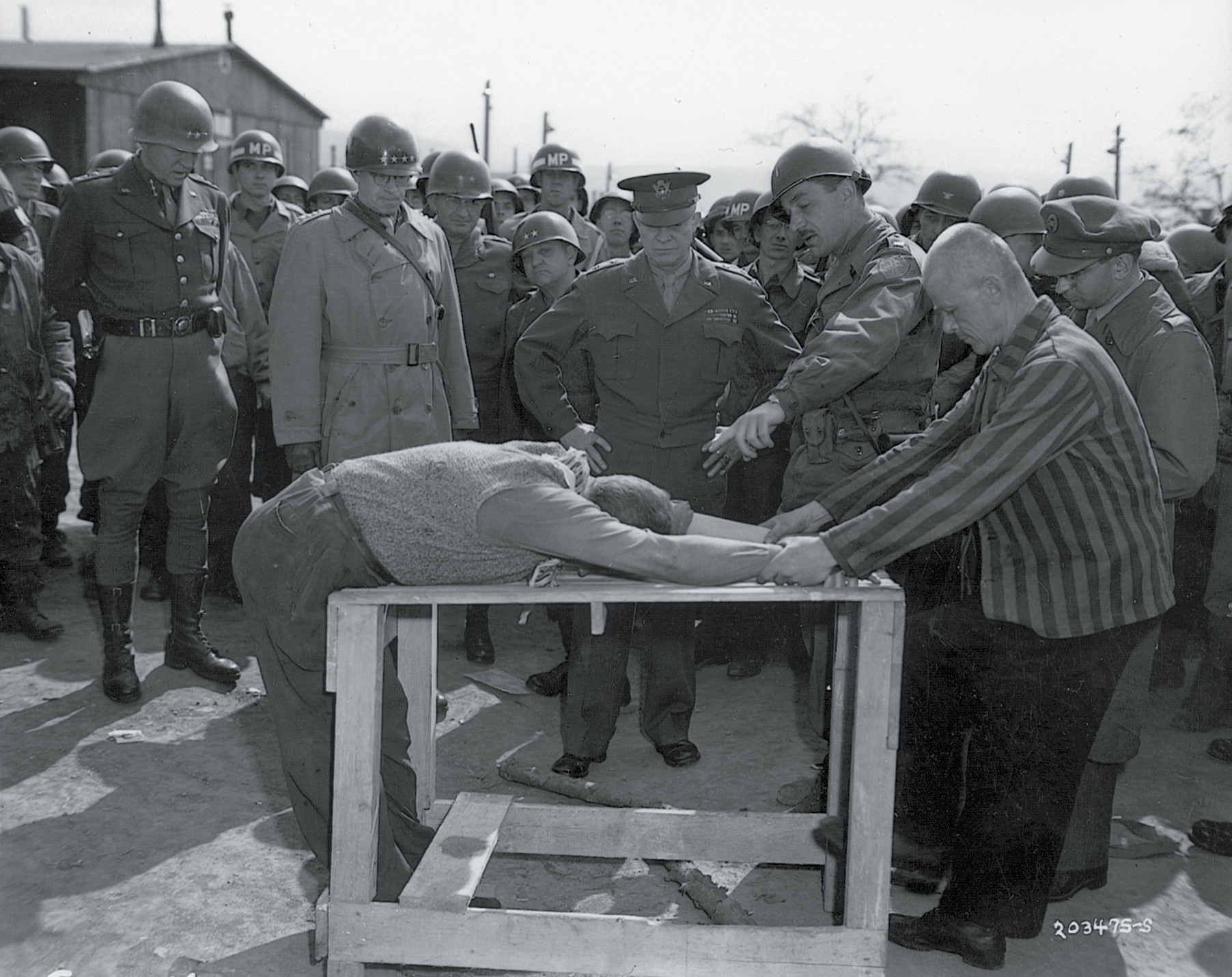General Eisenhower watches a demonstration of the thrashings suffered by prisoners at Gotha 
concentration camp. Patton and Bradley are to his right.