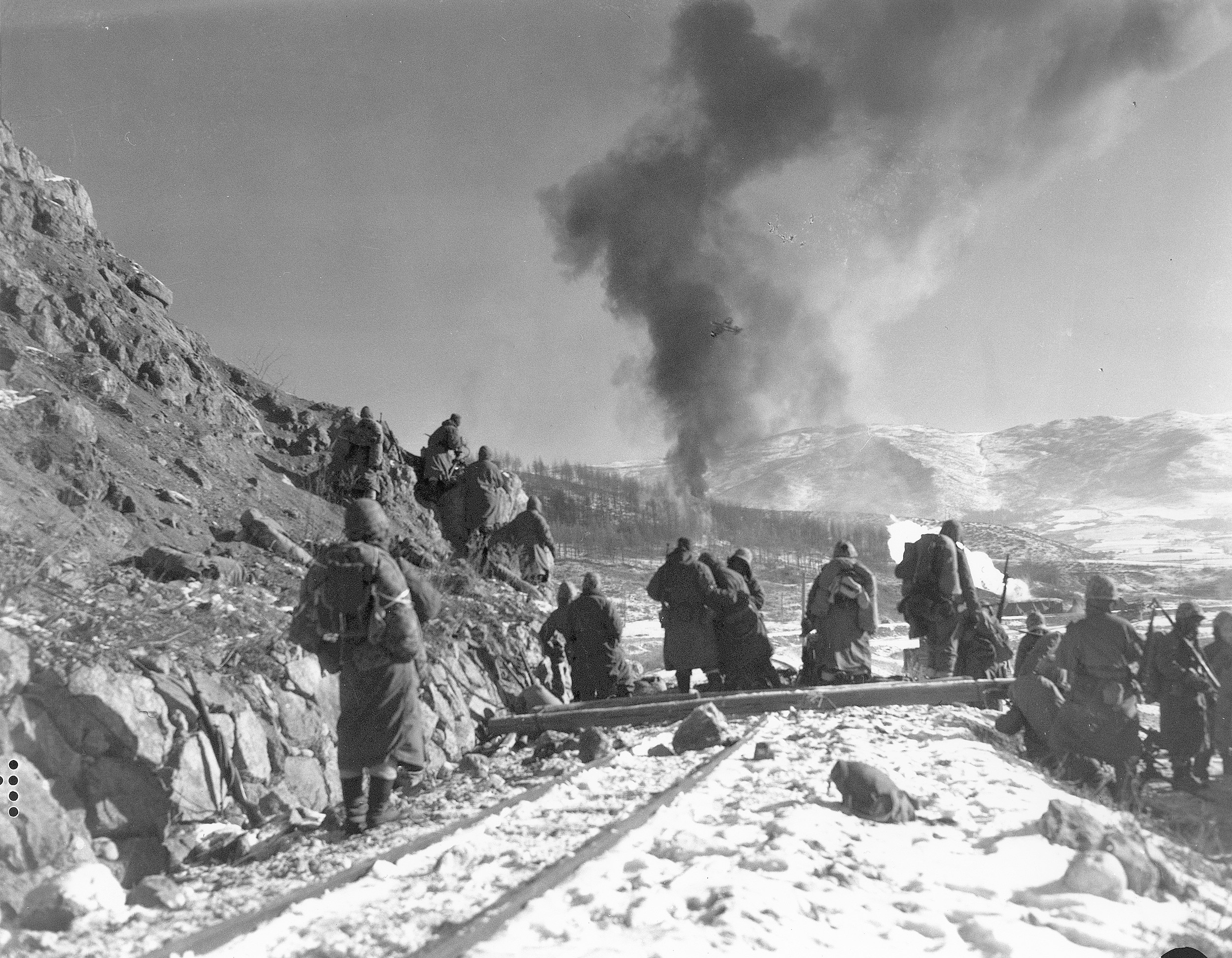 A Marine Corsair (barely visible in the smoke) strikes a Chinese position in support of Marines moving south.