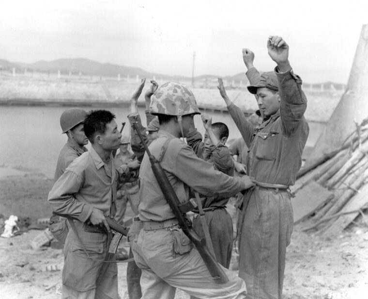 Americans and South Koreans search North Koreans captured in the surprise attack.