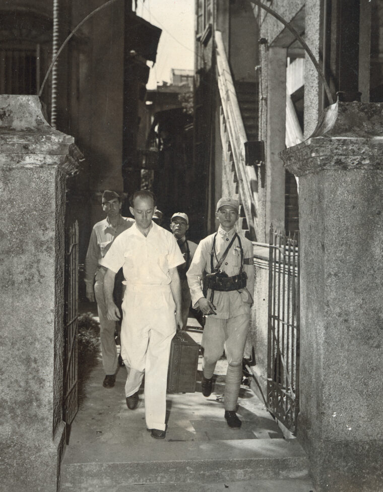 Captain Frank Ferrell, right, brings  in the Gestapo leader of Canton.  The Germans kept a spy ring in operation in China after Germany surrendered to the Allies.