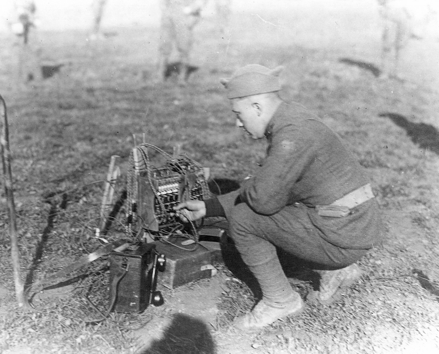 A soldier in France in 1918 operating a field telephone and switching station. 