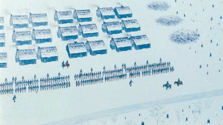 The huts of the Americans spread across sloping ground below the crest of Jockey Hollow, divided into eight infantry brigades. At lower right a regiment is formed in two ranks on the parade ground, while oxen drag timber for firewood at lower left.