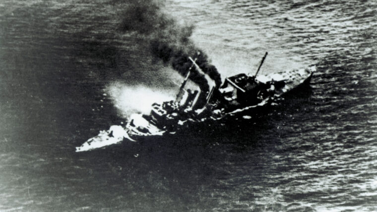 By 1940, cruisers built under the post-World War I naval treaties were feeling their age. Anove, a captured Japanese photo- graph shows the HMS Cornwall succumbing to an air attack.