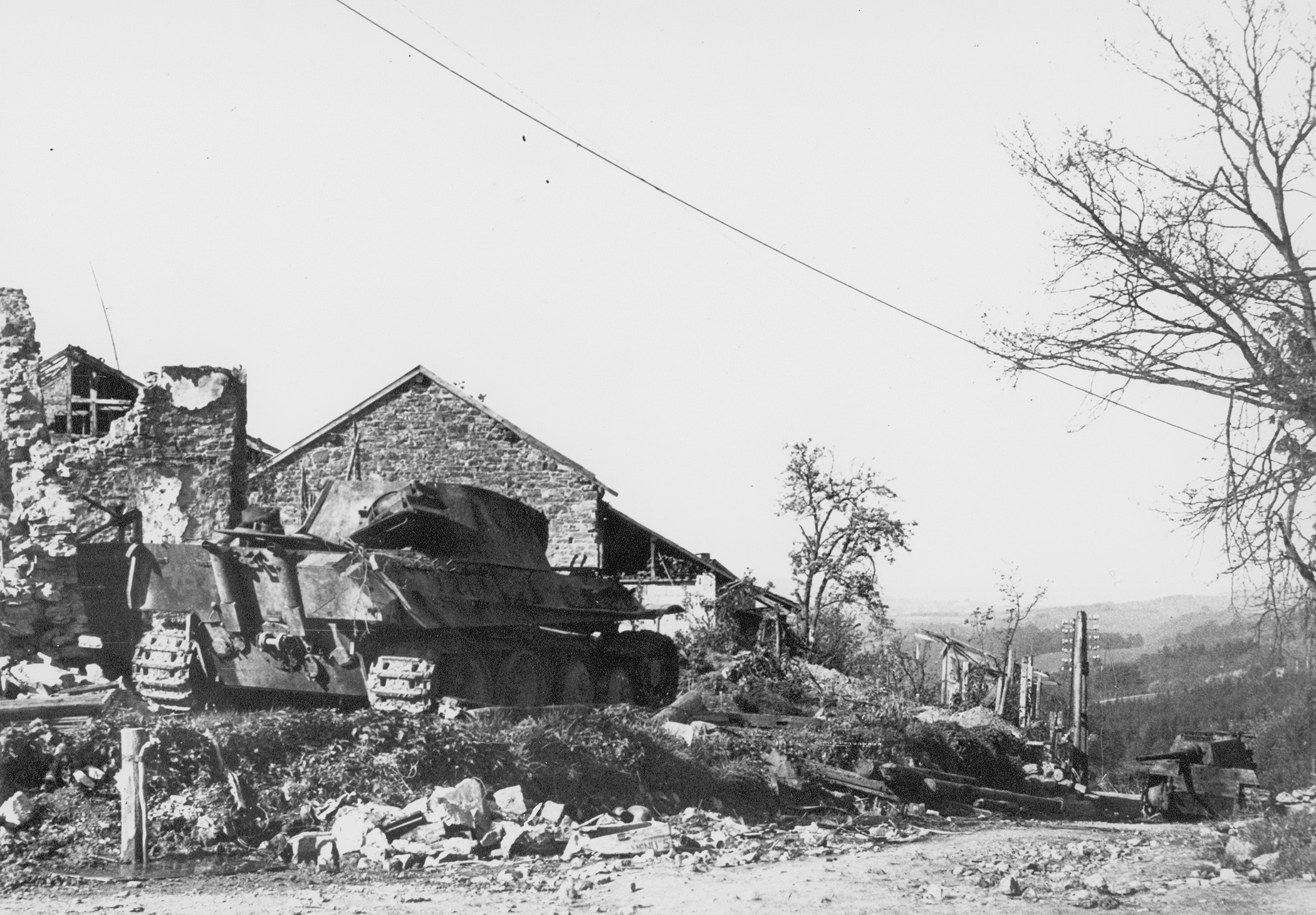 Following Peiper’s retreat from the Cauldron, a Panther medium tank (left) and a Tiger heavy tank lie derelict on a rubble-strewn hillside.