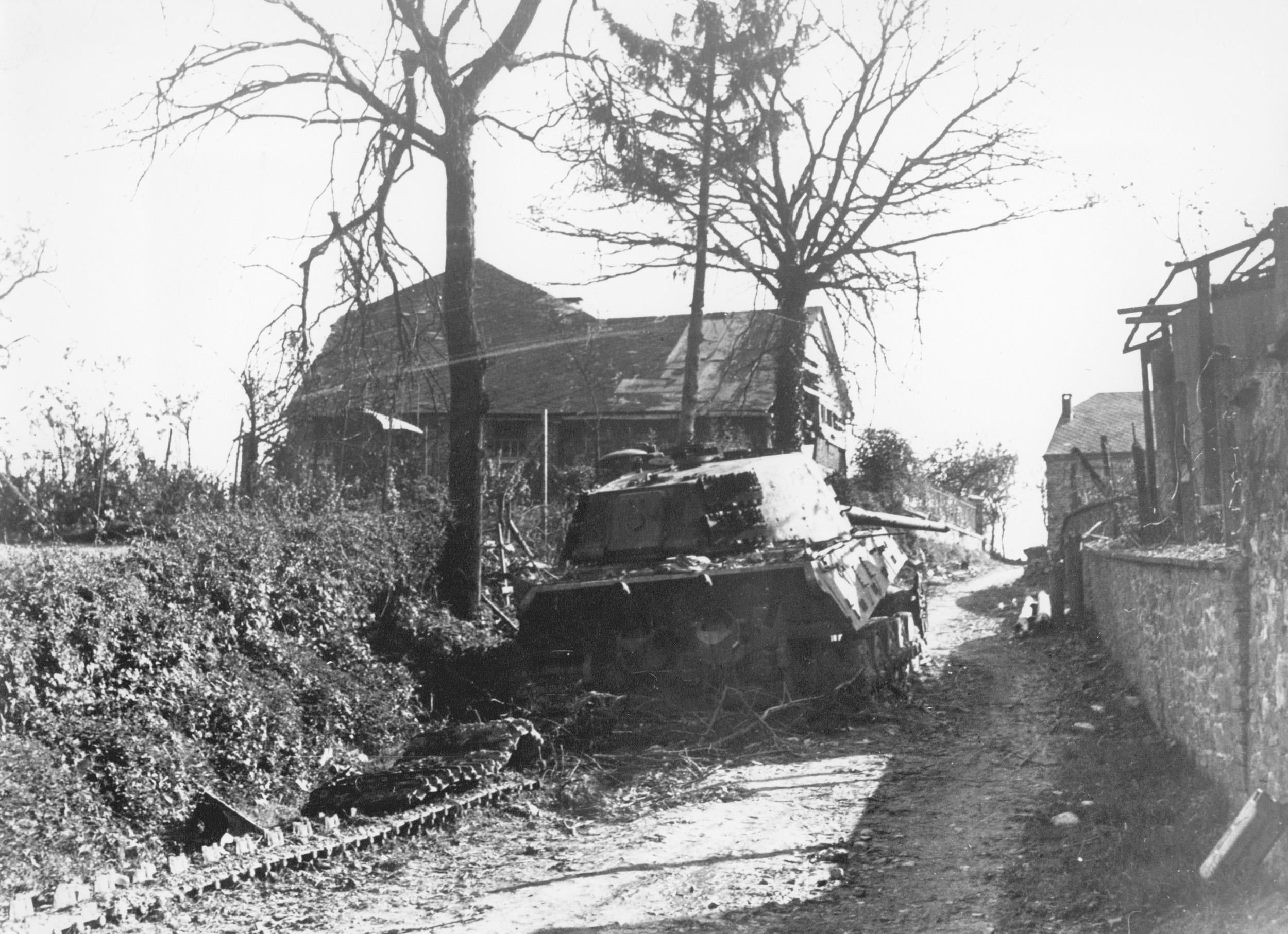 Destroyed by concentrated Allied fire, a burned-out German tank lies abandoned along a country lane in Belgium. Peiper’s armored force was severely mauled as the initial gains of the Bulge were contained.
